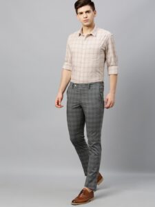 Man in casual attire wearing checkered grey chinos and check dress shirt